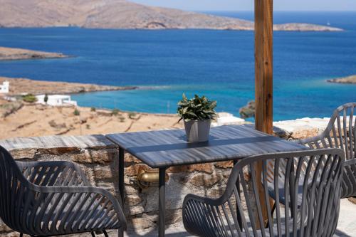 a blue table with two chairs and a potted plant on it at Kythea Suites Kythnos in Kithnos