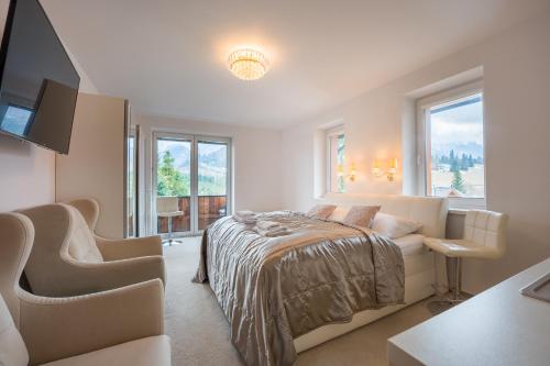 a bedroom with a bed and a tv and windows at Apartmany U Jezka in Ždiar