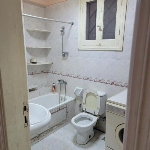 a bathroom with a toilet and a tub and a sink at OS & MA Luxor in Luxor