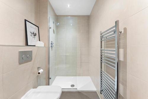 a white bathroom with a shower and a toilet at Designer Apartment in Central Lincoln - Sleeps 8 in Lincoln