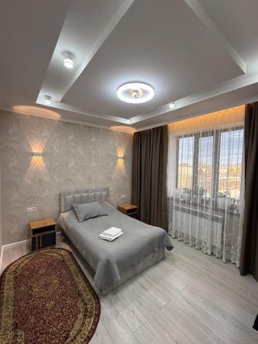 a bedroom with a bed and a large window at Rest House in Bokonbayevo