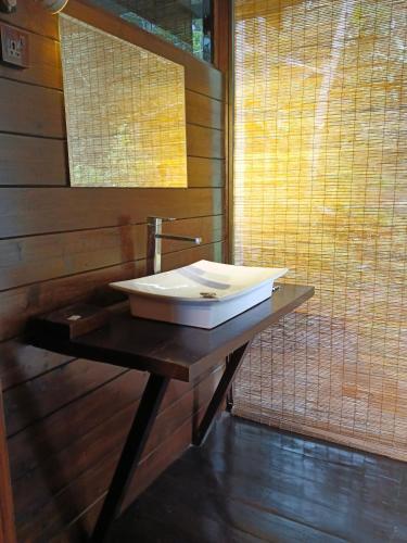 a bathroom with a white sink on a table at The Mist in Ella