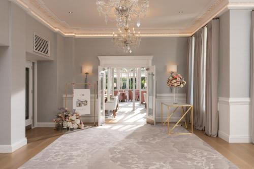 a hallway with a chandelier and a dining room at Tullyglass House Hotel in Ballymena