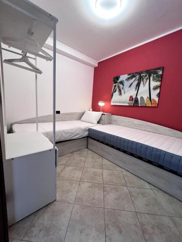 a bedroom with two beds and a red wall at Appartamento 37 Varazze in Varazze