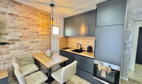 a kitchen with a table and a brick wall at Apartments St Jakov in Međugorje