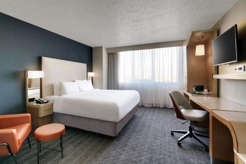 ein Hotelzimmer mit einem großen Bett und einem Schreibtisch in der Unterkunft Courtyard by Marriott Ogden in Ogden