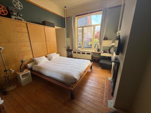 ein Schlafzimmer mit einem großen Bett und einem Fenster in der Unterkunft Lunatree in Mechelen