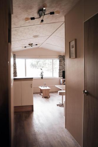 a living room with a ceiling fan and a table at De Wilg Beerse, tiny house with meadow view, animals in Beerse