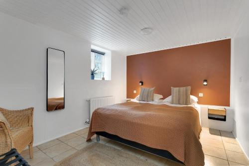 a bedroom with a bed and a chair at Grettir Guesthouse Downtown Charm in Reykjavík