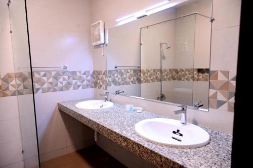 a bathroom with two sinks and a large mirror at Elevé Stays - Boutique Family Suites in Karachi