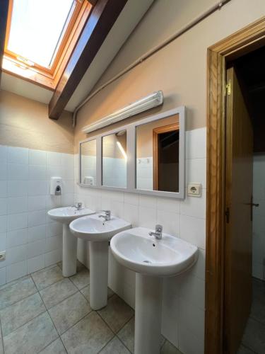 a bathroom with two sinks and a mirror at Amaiurko Aterpetxea in Maya del Baztán