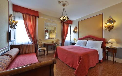 une chambre d'hôtel avec un lit et un canapé dans l'établissement Hotel Arlecchino, à Venise