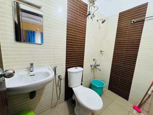 a bathroom with a toilet and a sink at two bedroom anandha vibes in Guruvāyūr