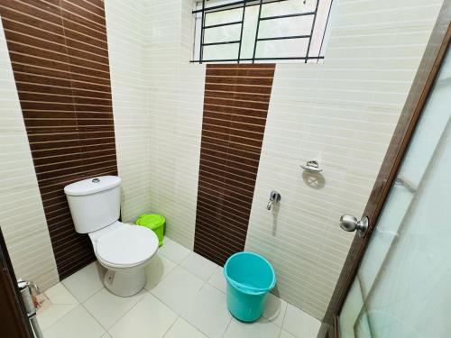 a small bathroom with a toilet and a shower at two bedroom anandha vibes in Guruvāyūr
