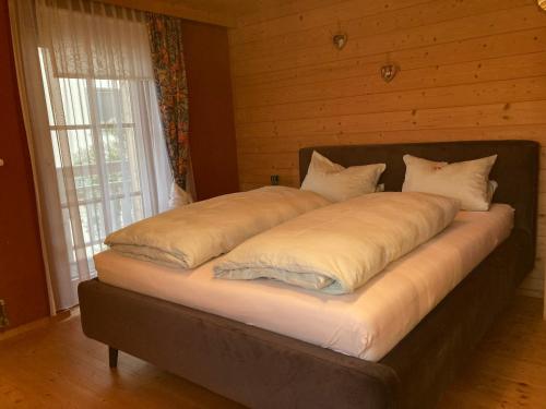 a large bed with pillows on it in a bedroom at Sissy Appartment in Kössen