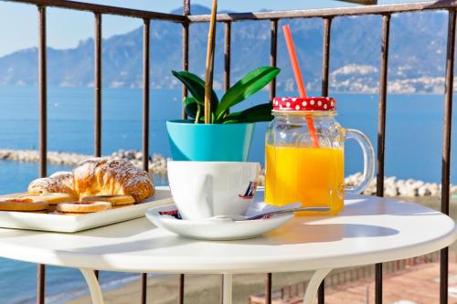 a table with a breakfast of coffee and orange juice at On the beach Sea-view&Kitchen In Room in Salerno
