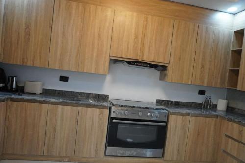 a kitchen with wooden cabinets and an oven at Yande Homes in Mama