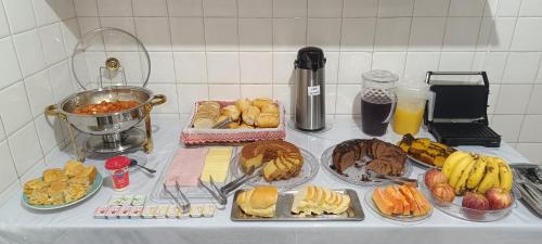 a table with a bunch of different types of food at Fazio Hotel in Jales