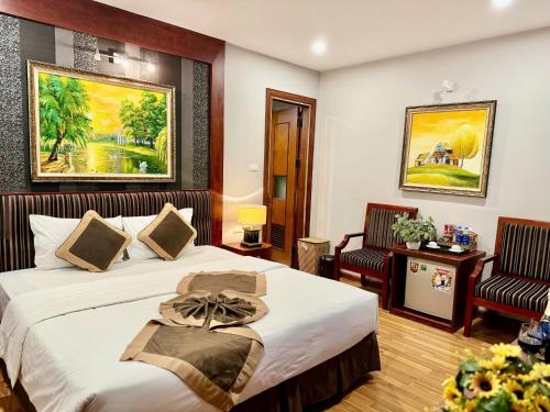 a hotel room with two beds and two chairs at Gllant Villa Hà Nội in Hanoi