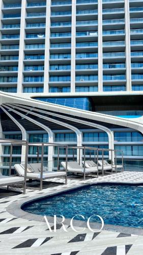a swimming pool in front of a large building at Mercury Suite Bright w Pool access by Arco Collection in St. Julianʼs