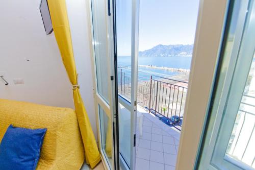 a room with a balcony with a view of the ocean at On the beach Sea-view&Kitchen In Room in Salerno