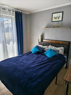 ein Schlafzimmer mit einem blauen Bett und einem Fenster in der Unterkunft 4 Foxes in Ustka