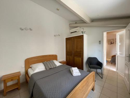 una camera da letto con un letto e una sedia di Hotel L'Escale ad Aigues-Mortes