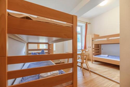 a room with three bunk beds and a desk at Luise Wehrenfennig & Haus EvA in Bad Goisern