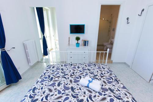 a bedroom with a bed with a blue and white bedspread at On the beach Sea-view&Kitchen In Room in Salerno