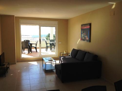 een woonkamer met een bank en een tafel bij Ático Ancla in L'Ametlla de Mar