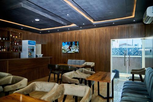 a restaurant with a table and chairs and a bar at Motion Hotel and Suites, Uyo in Uyo