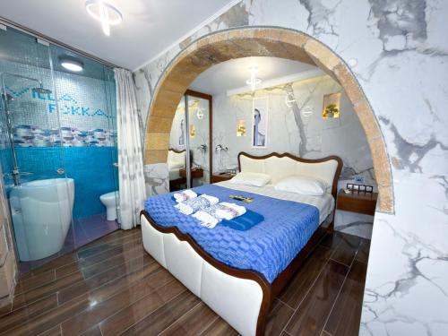 a bedroom with a large bed and a bathroom at Villa Rokka Luxe - Free Private Heated Pool, Hot Tub, and more in Kissamos