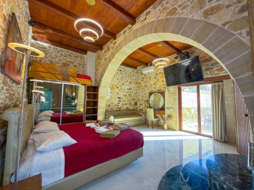 a bedroom with a large bed in a stone wall at Villa Rokka Luxe - Free Private Heated Pool, Hot Tub, and more in Kissamos