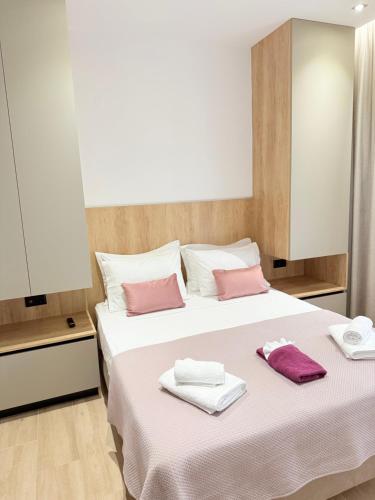 a bedroom with a bed with pink and white towels on it at Nido Estivo 1 in Nea Skioni