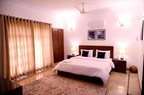 a bedroom with a large bed and two lamps on tables at Elevé Stays - Boutique Family Suites in Karachi