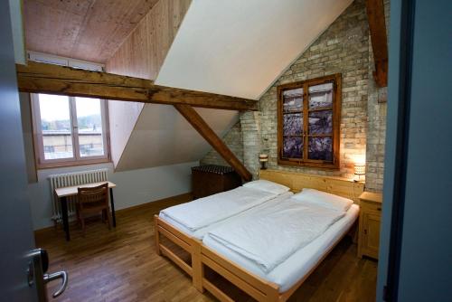 a bedroom with a bed and a table in it at Depot 195 - Hostel Winterthur in Winterthur