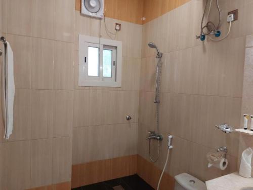 a bathroom with a shower and a toilet and a window at فندق السلطان ان Alsultan Inn Hotel in Jazan