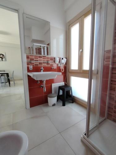 a bathroom with a sink and a red wall at OndaMaris Tropea in Tropea