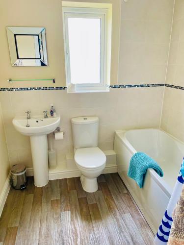 a bathroom with a white toilet and a sink at The Coach House in Par