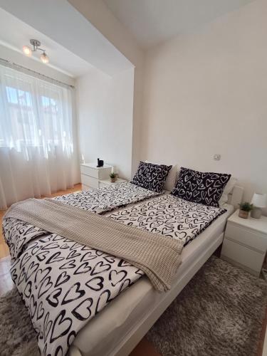 a bedroom with a large bed with black and white sheets at Venus Deluxe Apartment in Strumica