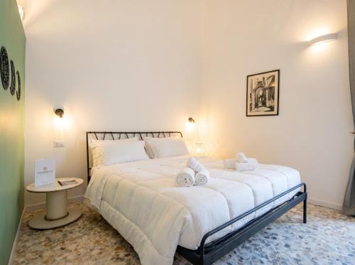 a bedroom with a large white bed with towels on it at Andromeda in Modugno