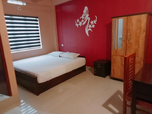 a bedroom with a bed and a red wall at Safa residency hotel in Perintalmanna
