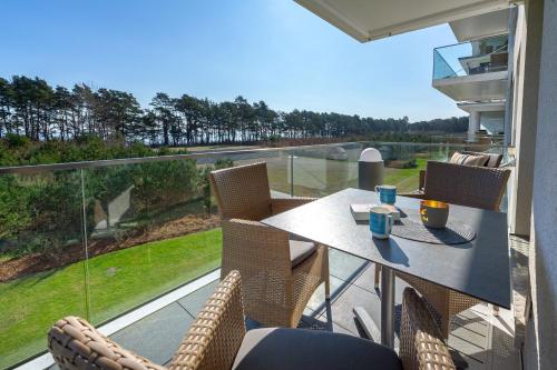 a table and chairs on a balcony with a view at Strandresort Prora - Wohnung 213 in Binz