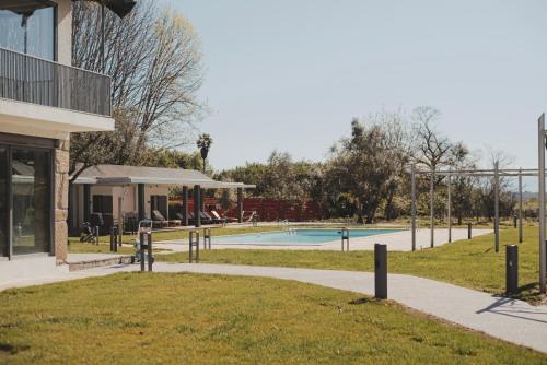 a park with a swimming pool and a building at ARTS IN Country House in Tondela