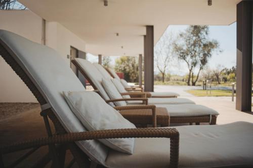 a row of chairs lined up in a row at ARTS IN Country House in Tondela