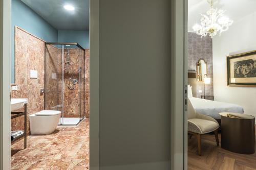 a bathroom with a shower and a toilet and a bed at Ca' Del Campo in Venice