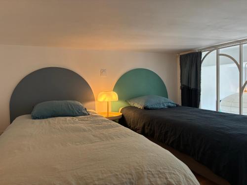 two beds sitting next to each other in a bedroom at Blue dream in Carantec