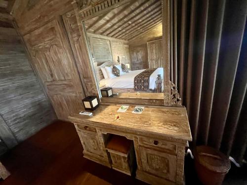 a bedroom with a bed and a large mirror at Casa Tibubiu in Tabanan