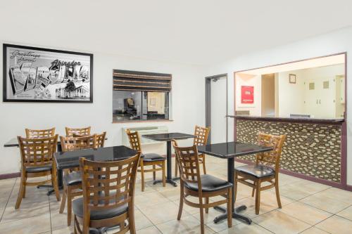a dining room with tables and chairs and a fireplace at Super 8 by Wyndham Abingdon VA in Abingdon