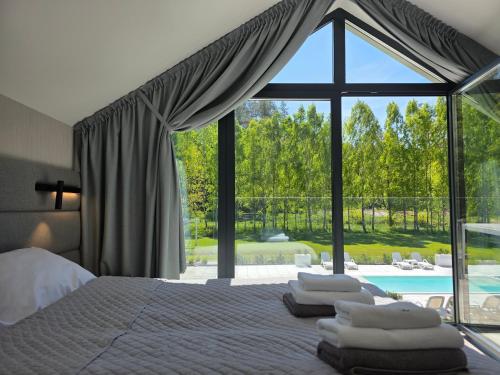 a bedroom with a bed and a large glass window at NOVA ULINIA Sand - dom nad morzem, podgrzewany basen,sauna, balia z jacuzzi , Starlink in Ulinia